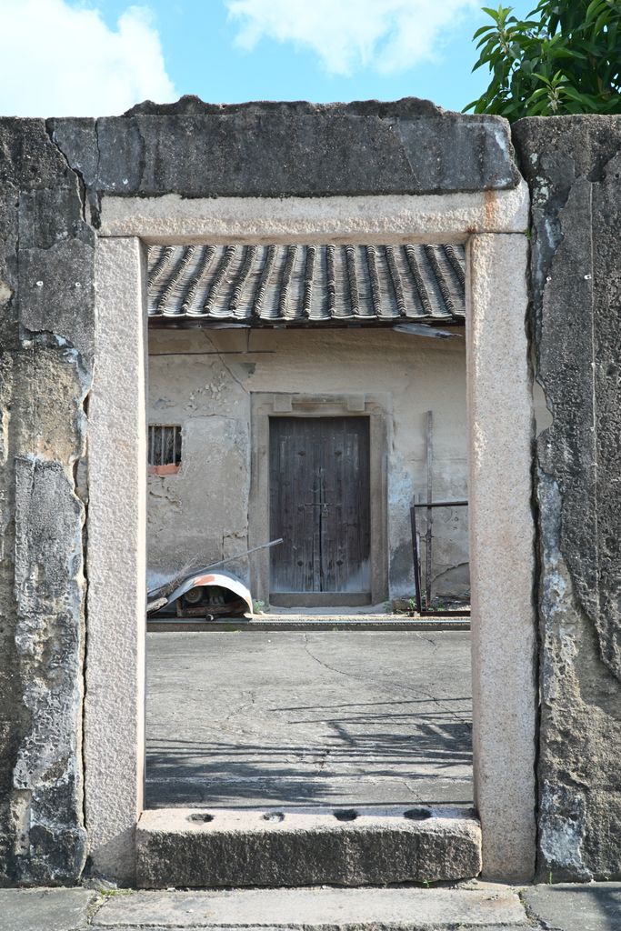 Stone doorway leading to a weathered wooden door, showcasing rustic architecture.